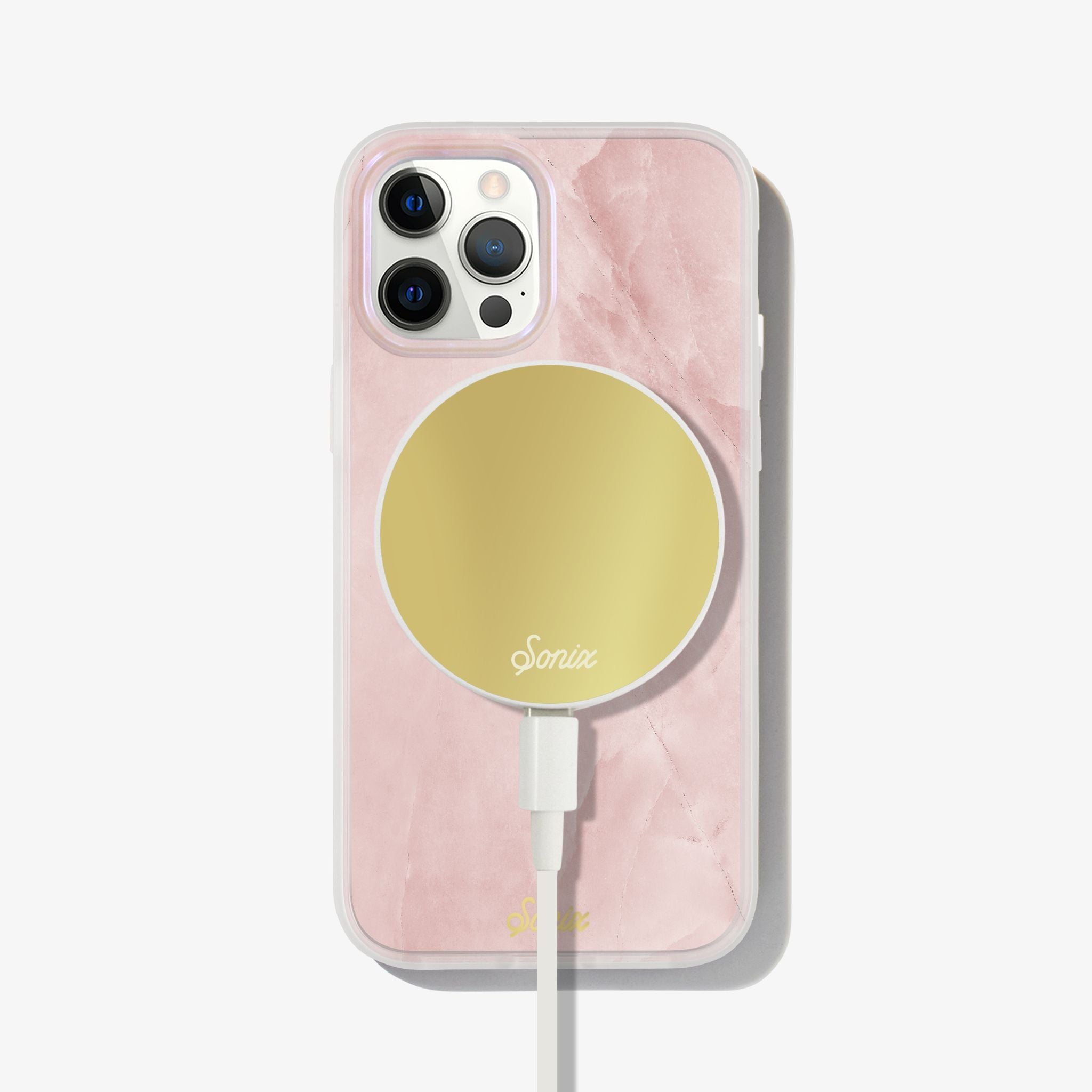 a gleaming pearl design with a pink finish shown on an iphone 12 with a gold maglink charger on the back 