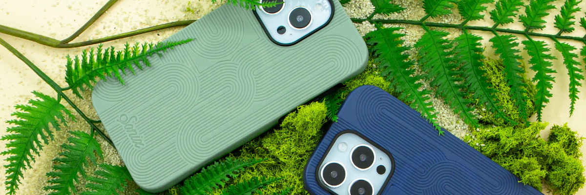 Angled top-down view of two Sonix iPhone Cases showing textured swirl pattern and camera cutouts on moss and ferns