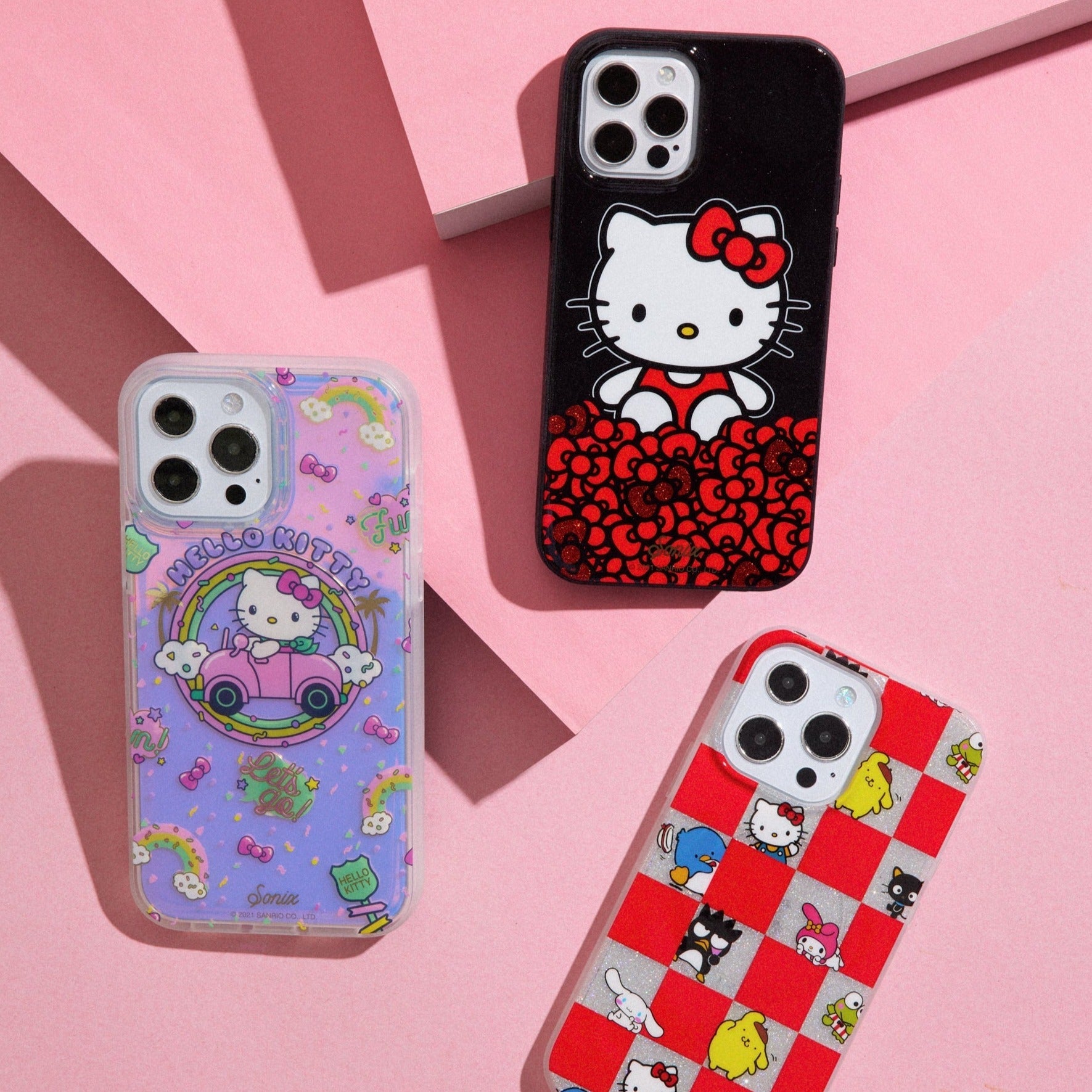 three hello kitty themed phone cases displayed on a pink background
