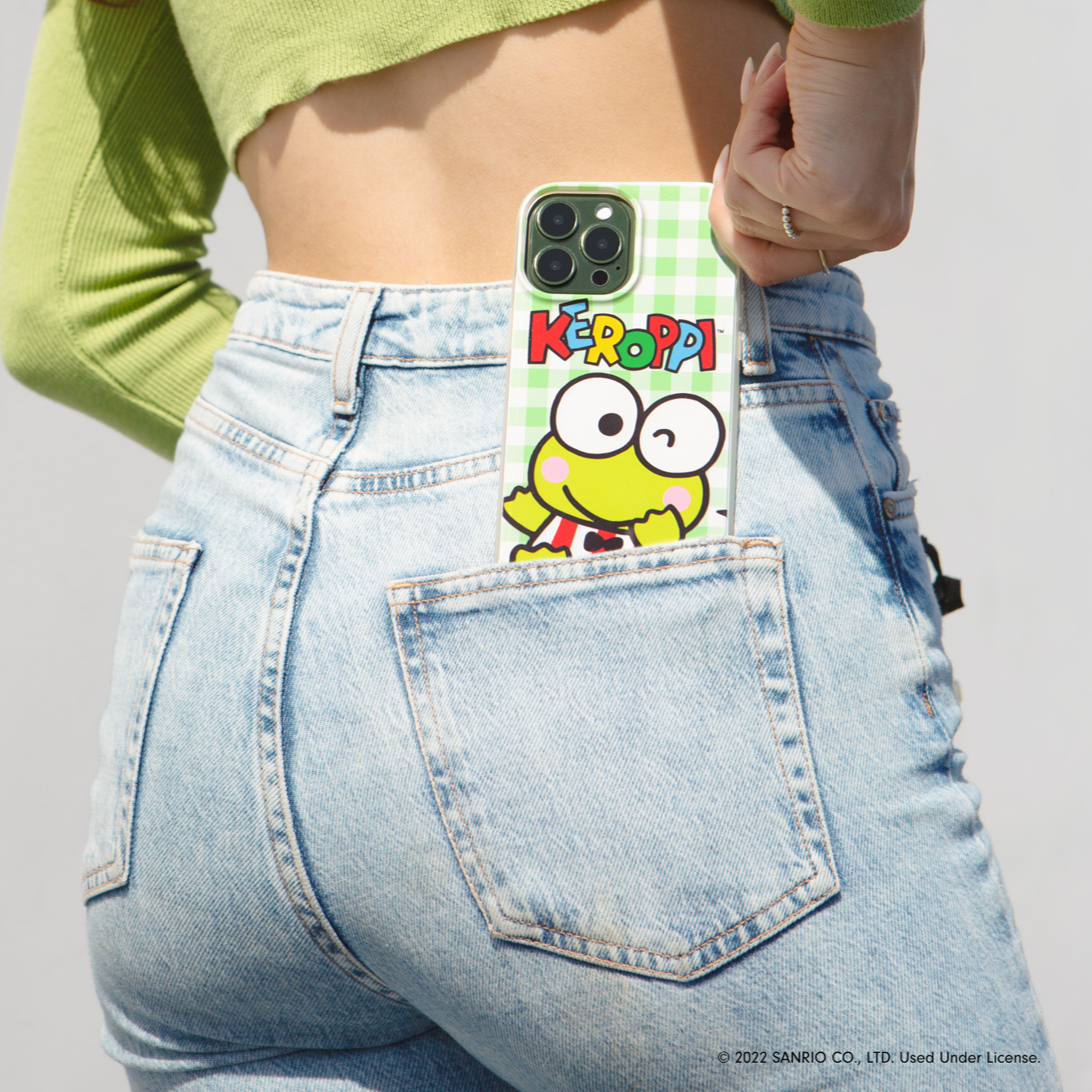 green gingham iphone case featuring keroppi frog from sanrio on green iphone 13 pro pulling out of back pocket of green by girl wearing green sweater