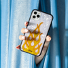 white tortoise shell with an orange flame in the middle of the case shown on an iphone 11 pro max