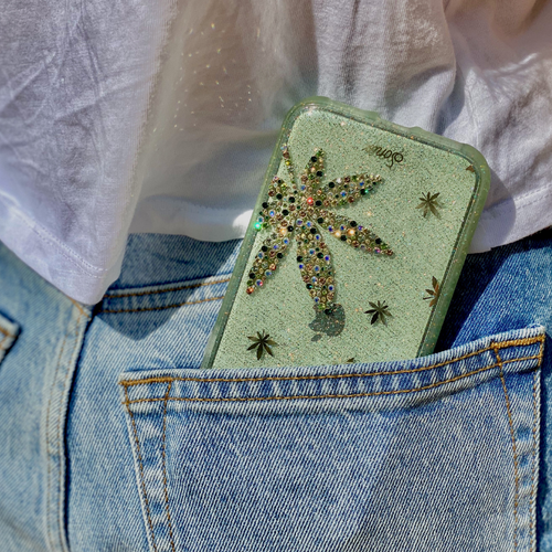 a leaf design, embellished with an assortment of green rhinestones shown in the back pocket of shorts