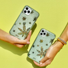 a leaf design, embellished with an assortment of green rhinestones shown on two iphones being held by a hand each