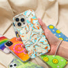 metallic oranges, blues, and cream colors in a wavy 70's pattern shown on an iphone being held by a hand with other phone cases in the background