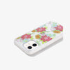 Clear iPhone case featuring deco floral art with pops of vibrant colors and gold foiling modeled on white iphone 12